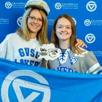Two alumni pose with props at the Laker Legacy Brunch